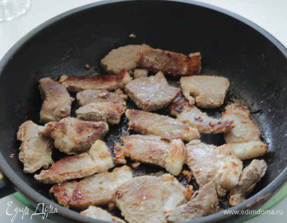 Духовку разогреть до 170С.
В сковороде (жаровне), которую можно поставить в духовку, обжарьте нарезанное на кусочки мясо до золотистой корочки.