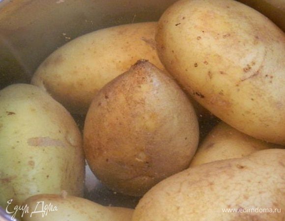Картофель хорошо помыть с щеточкой. Сложить в кастрюлю, залить водой и отварить до готовности. Остудить и разрезать на две части вдоль.
