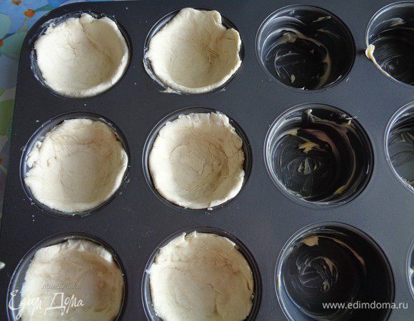 Распределить тесто по формочкам, предварительно раскатав его в кружочек.