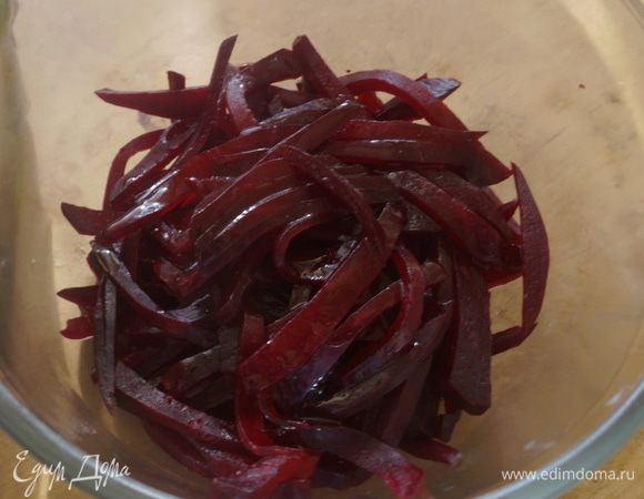 Сначала замаринуем свеклу. Для этого смешаем в чаше уксус и оливковое масло, посолим, поперчим, добавим сахар и выдавленный через пресс чеснок. Все перемешаем.

Свеклу нарежем длинной тонкой соломкой, выложим в глубокую чашу и зальем маринадом. Маринуем в течении 1-1,5 часов.