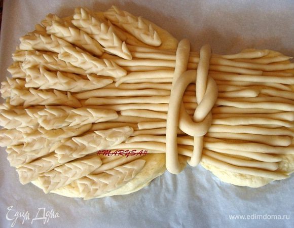 Когда основа снопа подойдет, нужно разрезать пергамент и удалить его.
Сначала выложить стебельки, потом сами колосики, формируя сноп.
Из оставшегося кусочка белкового теста, скатать длинный жгут, разрезать его пополам, подсунуть концы под сноп и красиво завязать.