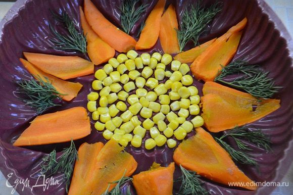 Заранее отварить морковь и нарезать пластинами. На дно формы уложить кукурузу по центру, морковь по размеру лепестков формы и зелень укропа между лепестками.