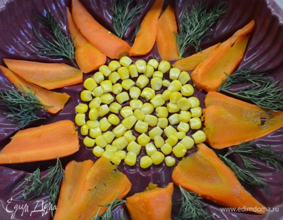 Заранее отварить морковь и нарезать пластинами. На дно формы уложить кукурузу по центру, морковь по размеру лепестков формы и зелень укропа между лепестками.
