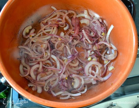 Красную луковицу очистить и тонко нарезать полукольцами. В сотейнике, который после можно поставить в духовку, разогреть 2 ст. л. оливкового масла и положить обжариваться лук до золотистого цвета. 