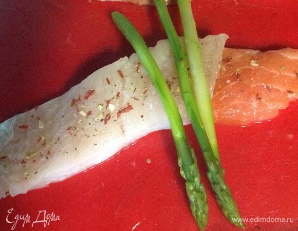 Укладываем филе семги, сверху-филе судака и раскладываем по 3 стебелька спаржи. Сворачиваем в рулетики.