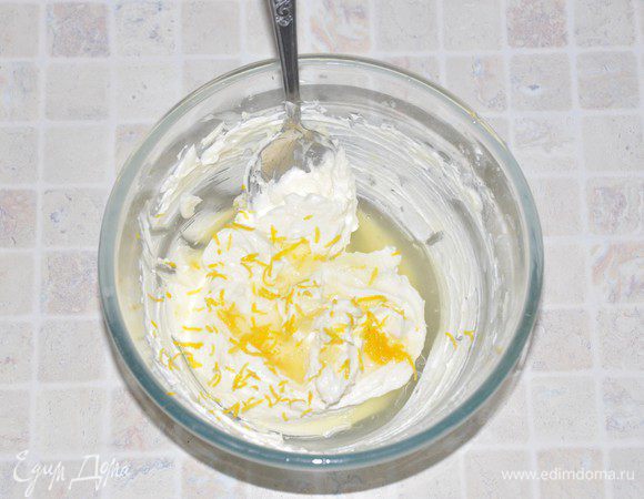 Испечем основу для "яичницы". Включить разогревать духовку до 180 градусов. 
В  миске недолго взбить сливочное масло. Добавить сахарный песок и взбить их до пушистого состояния. На это уйдет 6-8 минут. Не забывайте периодически соскребать со стенок миски и венчика масло, чтобы все хорошо перемешалось. Добавить сок и цедру половины лимона.

