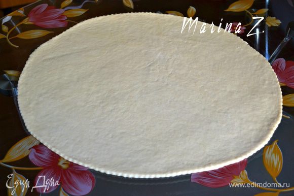 Тесто вынуть из пакета, слегка помять на столе. Разделить его на 4 части (хватит на 2-3 больших пирога). Одну часть раскатать в овал толщиной примерно в 7 мм.
