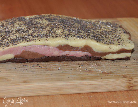 Закрываем слоем темно-коричневого теста. Потом переворачиваем всю заготовку светлым тестом вверх. Присыпаем немного солью и «поперчим» размолотыми в кофемолке семенами мака. Завернуть в пленку и убрать тесто в холодильник на 2 часа. 
