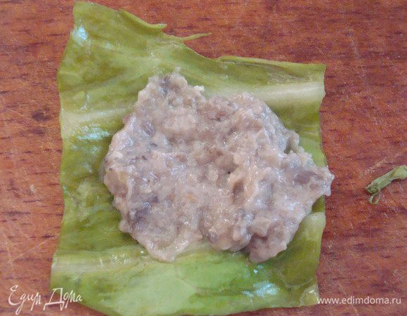 Взять маленький кусочек капусты, примерно 2,5*3,5 см, выложить чуть начинки.