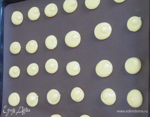 Отсадить пирожные из кондитерского мешка на противень, застеленный бумагой для выпечки.