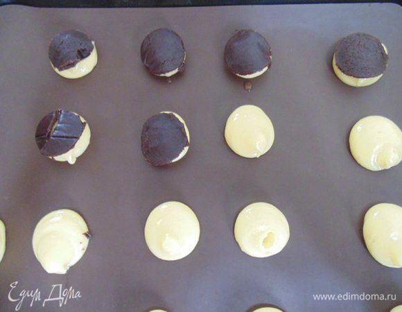 Кракелин: Масло комнатной температуры растереть с сахаром, мукой и какао до состояния мягкого теста.Раскатать между двумя листами пергамента толщиной 2 мм. Убрать в морозильную камеру до застывания.
Вырезать «монетки» из кракелина формочкой, выложить лопаткой сверху на пирожные. Работать нужно быстро, потому что тесто быстро тает.
Выпекать 30 минут, духовку во время выпечки не открывать, чтобы пирожные не опали. Пирожные остудить.