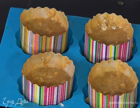 В формы для маффинов вставить бумажные вкладыши и разложить тесто, наполняя их на 2/3 объема.