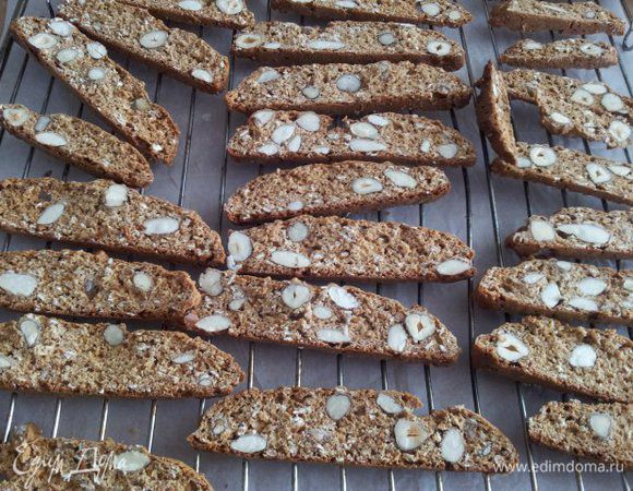 После того как бискотти остынут, нарезаем 1-1,5 см хлебным ножом с зубчиками, тогда выйдет ровно (у меня ножа такого не было, поэтому нарезала как смогла большим ножом для мяса).
Снова нагреваем духовку, в этот раз на 140 градусов. Нарезанные бискотти раскладываем на решетке. Сушить 15-20 минут до золотистого цвета. Бискотти должны стать тверденькими, но не подгорелыми.