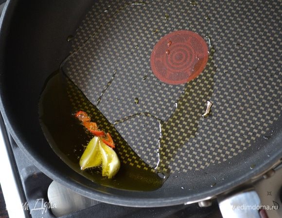 Чеснок очистить и удалить сердцевину, разрезав зубчик пополам. Перчик чили нарезать, удалив все семена. В сковороде разогреть оливковое масло и обжарить в нём, постоянно помешивая, чтобы не пригорели, чеснок и перчик чили. Как только чеснок зарумянится, удалите его из сковороды вместе с чили.