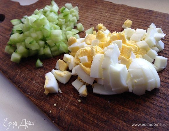 Замочить изюм в холодной воде на 5-10 минут, затем обсушить его. 
Яйца сварить, очистить и мелко нарезать. Также мелко нарезать огурец (если маленькие, то 2-3шт, у меня был большой).