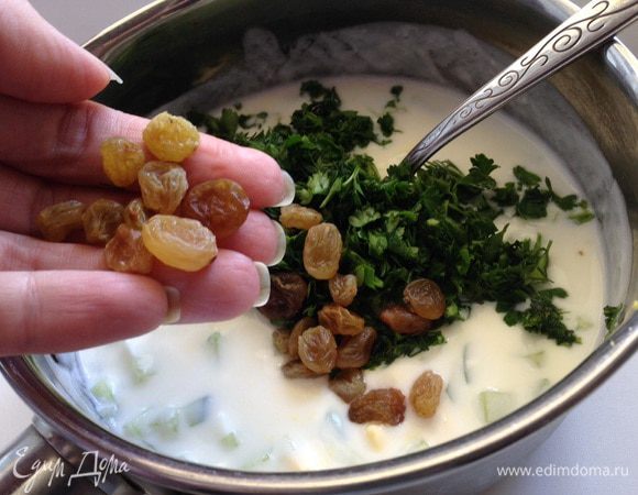 К йогурту заправить горчицей. Затем добавить яйца, огурец, зелень и горсть изюма. Хорошо все перемешать.