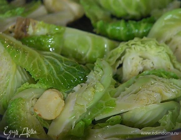 Выложить в сковороду капусту и обжаривать вместе с чесноком на сильном огне пару минут.