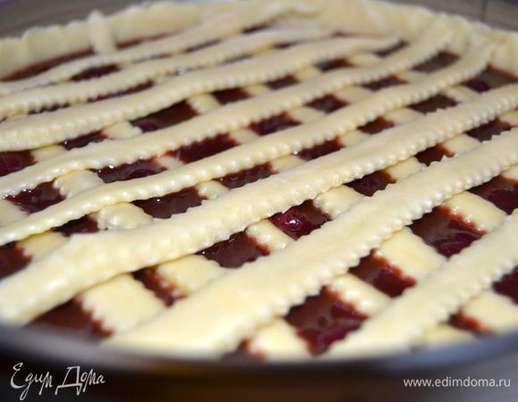 На тесто выложить охлажденную начинку. Сверху украсить нарезанными полосками.