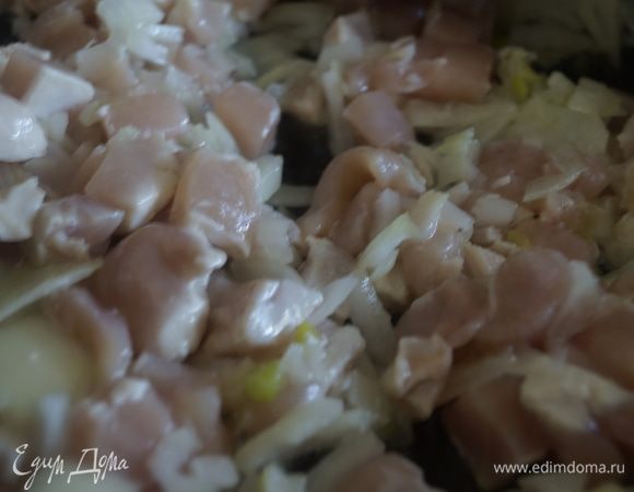 Теперь примемся за начинку. Для этого куриное филе режим небольшими квадратиками. Лук также мелко режем. Обжариваем на сковороде с оливковым маслом куриное филе, чеснок и лук.
