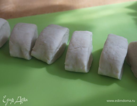 Тесто достаем из холодильника и формируем из него колбаску, делим на несколько частей. У меня получилось 9 равных частей.