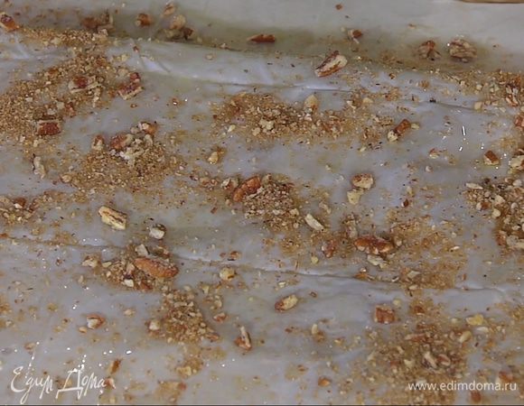 Смазанную сторону фило посыпать измельченными орехами со специями, сверху смазанной стороной вверх поместить второй пласт фило и посыпать ореховой крошкой.