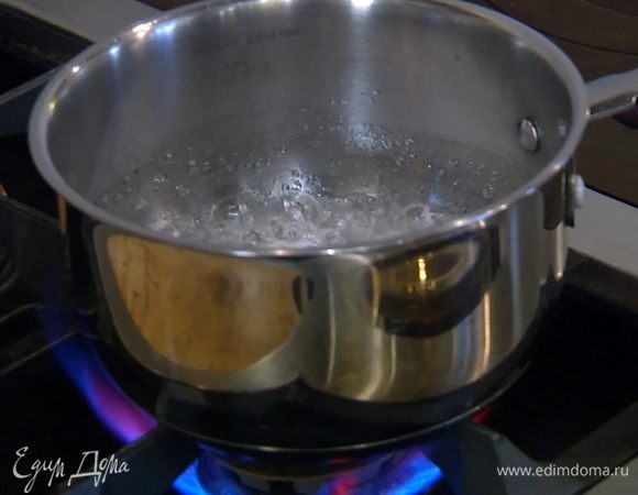 Сахар всыпать в небольшую кастрюлю, влить 50 мл воды и сварить светлый сироп.