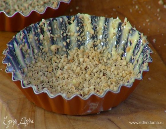 Небольшие широкие формочки смазать сливочным маслом и посыпать ореховой крошкой.