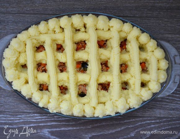 Кондитерский мешок с фигурной насадкой заполняем картофельным пюре. Выдавливаем пюре на овощи с фаршем в виде решётки. Так делаем 2-3 раза, чтобы слой был достаточно толстым. В конце выкладываем пюре по периметру формы для запекания. Получается такой вот нарядный "пирожок".