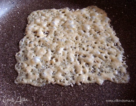 Поставить на огонь, дать сыру расплавиться и прожариться. Он должен пузыриться. Как только весь сыр "прокипит" и краешки чуть начнут схватываться корочкой, сковороду нужно убрать с огня.