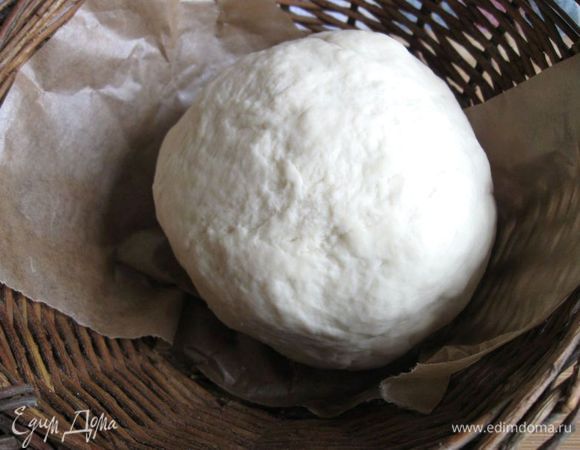 Муку просеять. Приготовить опару: смешать дрожжи, сахар и 2 столовые  ложки теплой воды. Добавить 2 столовые  ложки  муки, хорошо перемешать, накрыть полотенцем и поставить в теплое место на 30 минут. Оставшуюся муку высыпать на рабочий стол, в середине сделать углубление, в которое поместить опару, посолить, добавить  воду чуть выше температуры тела. Должно получиться тесто, которое не липнет к рукам, оно должно быть гладким и эластичным (месить примерно 10-15 минут). К рукам оно перестанет липнуть немного раньше, чем вам следует прекратить замес (добиваемся эластичности и гладкости).
