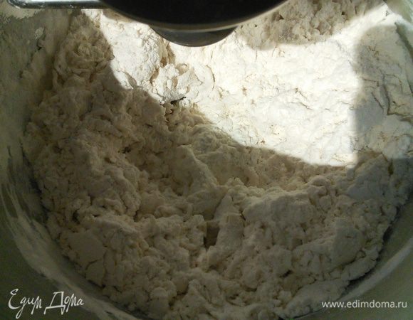 В муку влейте 130-150 мл тёплой воды и на маленькой скорости вымесите до состояния крошки. Не переставая вымешивать влейте 50-60 мл газированной воды и вымешивайте ещё 1 минуту. У меня жидкость ушла по-максимуму, зависит от муки. Далее влейте масло и замешивайте до тех пор пока тесто не соберётся в шар. 