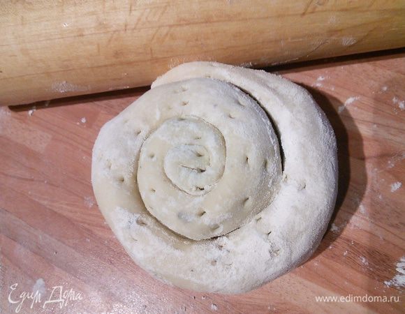 Заверните в рулет, скрепите края, а затем закрутите в улитку швом вовнутрь. Сделайте вилкой несколько проколов.