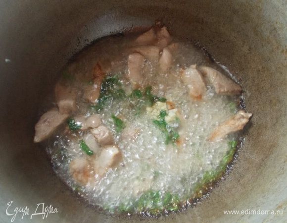 В казане разогреем масло, пока не пойдет дымок, сразу выкладываем мясо, посыпаем его чесноком и зеленью. Мешаем, пока не появится золотистый цвет. Это произойдет довольно быстро, поэтому советую, все держать под рукой уже в нарезанном виде.