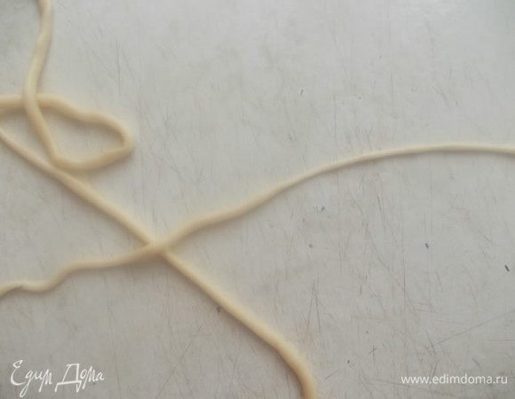 Ставим на огонь кастрюлю с подсоленной водой для варки лапши и начинаем ее тянуть, самая ответственная работа. На стол берем одну полосочку теста из тарелки и начинаем одной рукой раскатывать, а второй тянуть лапшинку дальше пальчиками. Чем-то похоже на то, если кто видел, как прядут нитки шерстяные на веретене, работа пальчиками та же. Не бойтесь, лапша упругая и не будет рваться, ну конечно если ее специально не тянуть!