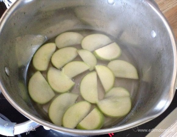 С сахара и воды сварить сироп и на медленном огне варить дольки до прозрачности.