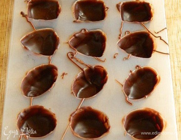 Кисточкой или пальцем, смазать стенки формочек шоколадом. Убрать в холодильник для застывания.