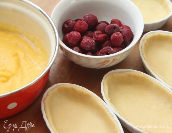 В формочки с тестом выложить заварной сливочный крем, сверху вишню (у меня замороженная, сразу из морозилки). 