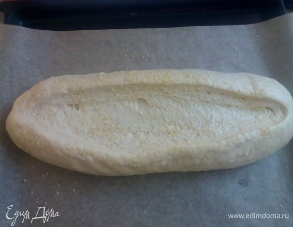 После того как подойдет, смазать молоком и сделать посередине разрез, глубиной 1 см. Опять смазать молоком и посыпать кунжутом. 