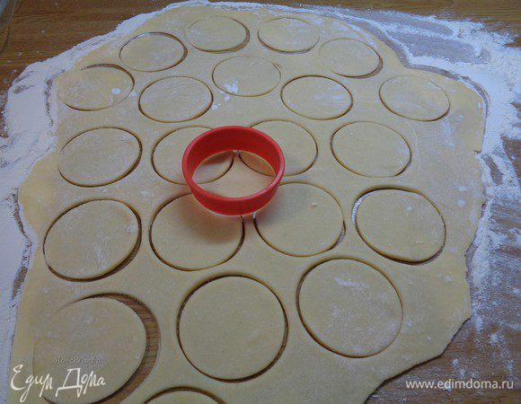 Тесто поделить на 2 части. На посыпанном мукой столе, раскатать тонкий пласт. Стаканчиком или формочкой выдавить кружки.