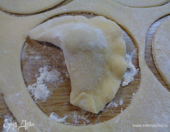 Затем, начиная с уголка, как бы внахлест подворачиваем тесто наверх.