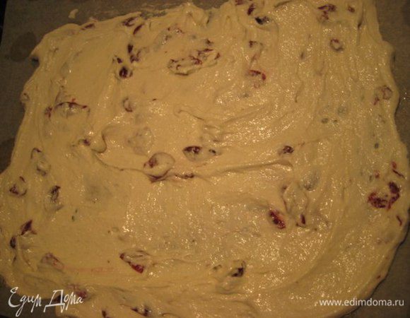 В белки аккуратно подмешать миндально-мучную смесь и в конце добавить кусочки отжатой и высушенной бумажными полотенцами "пьяной вишни". Выложить тесто на пергамент, смазанный маслом, разровнять,выпекать 10-12 минут до слегка золотистого цвета. 