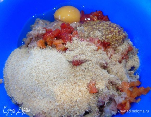 Добавить в фарш орегано, нарезанный болгарский перец, чеснок, горчицу, сухари, яйцо. Посолить, поперчить и хорошо перемешать.