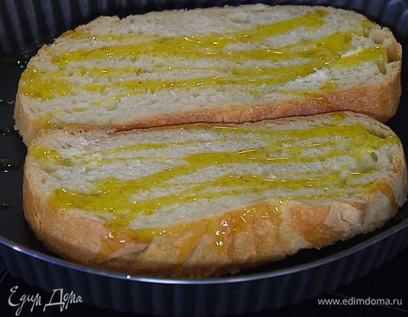 Хлеб поместить в небольшой противень, сбрызнуть оливковым маслом и запекать под грилем до золотистого цвета.