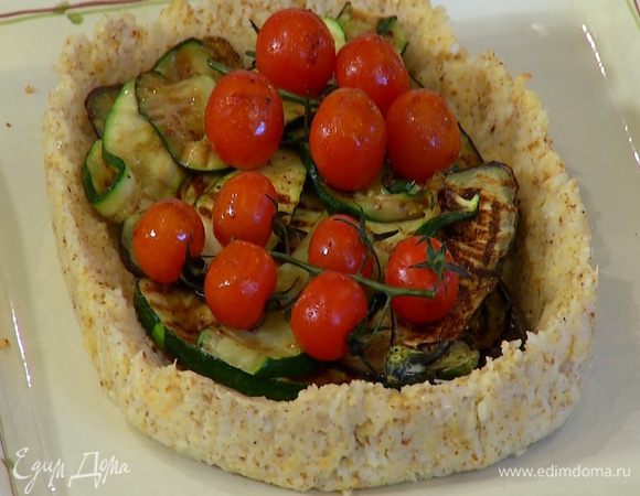 Готовый корж отделить от бумаги и переложить на блюдо, сверху разложить обжаренные баклажаны, цукини и помидоры.