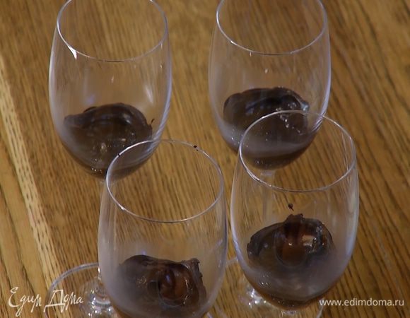 Половину горячего растопленного шоколада выложить небольшим слоем на дно прозрачных бокалов и дать остыть.