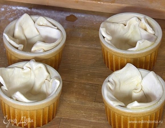 Смазать тесто оливковым маслом, выложить в небольшие керамические формы смазанной стороной вниз и сформировать высокие бортики.