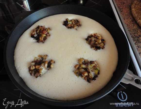 Через 15 минут залейте грибы яичной массой и готовьте еще 5-7 минут.