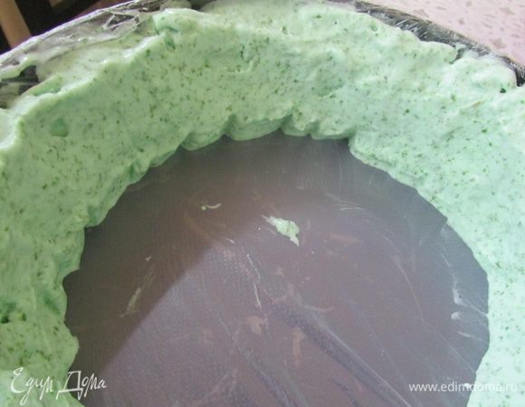 Разъемную форму (у меня 21 см) застелить пищевой пленкой (боковые стенки тоже застелить пленкой). Аккуратно выложить слой мятного мороженого, потом слой белого.