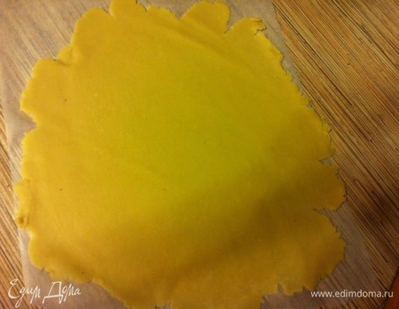 Достать тесто, раскатать между двумя листами пергамента как можно тоньше.
