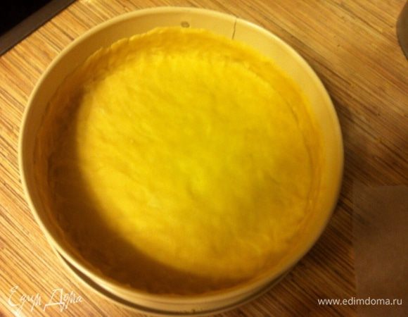 Выложить в форму, наколоть часто вилкой, поставить на полчаса в холодильник или на 10 минут в морозилку. Это нужно, чтобы край не осел. 